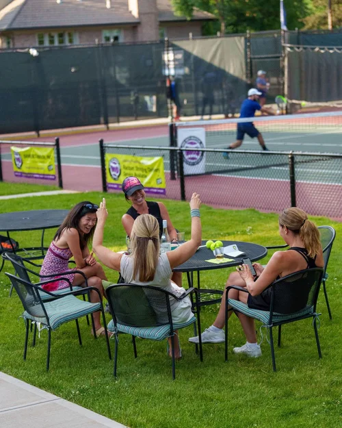Friends socializing courtside at Denver City Open